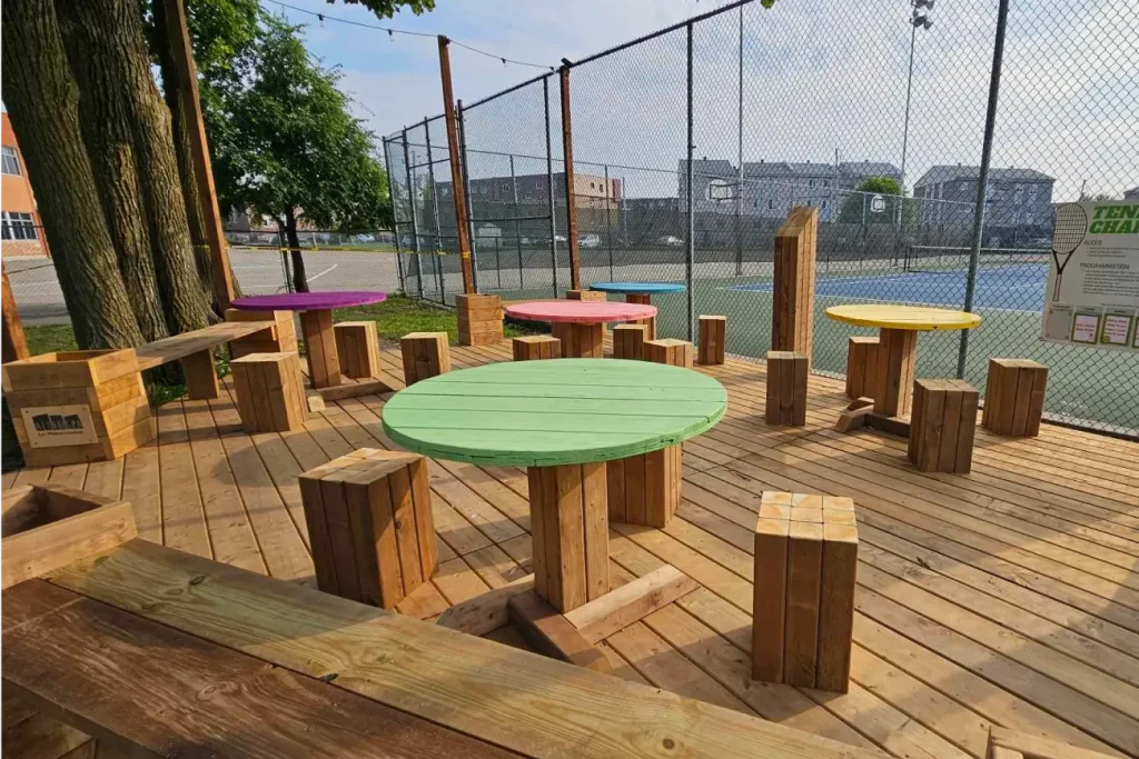 Terrasse urbaine animée par des tables rondes peintes de différentes couleurs