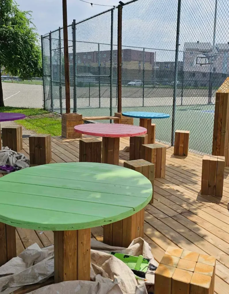 Tables rondes en bois en cours de peinture colorée sur terrasse extérieure