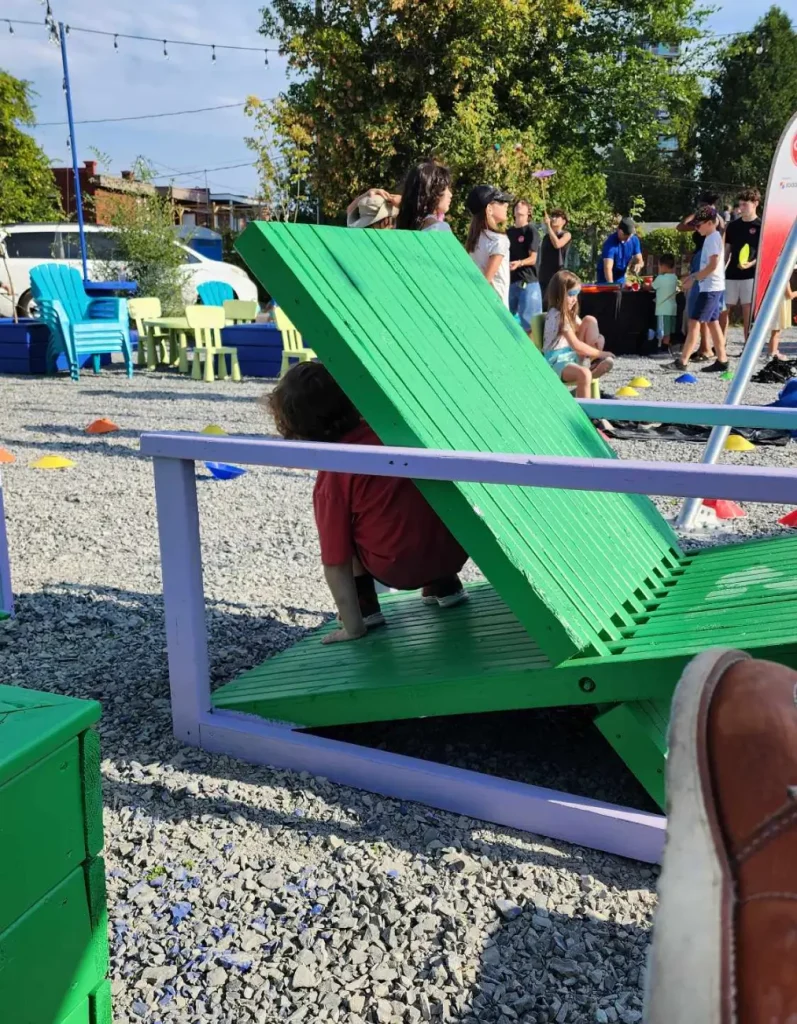 Enfant jouant dans une chaise géante en bois dans l'Oasis Cartier