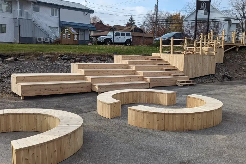 Gradins en bois et bancs circulaires créant un espace public au quai.