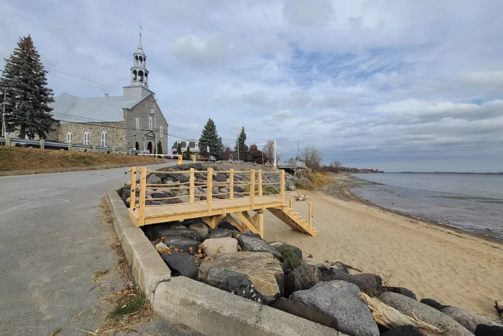 Passerelle en bois reliant la route et la plage devant l’église.