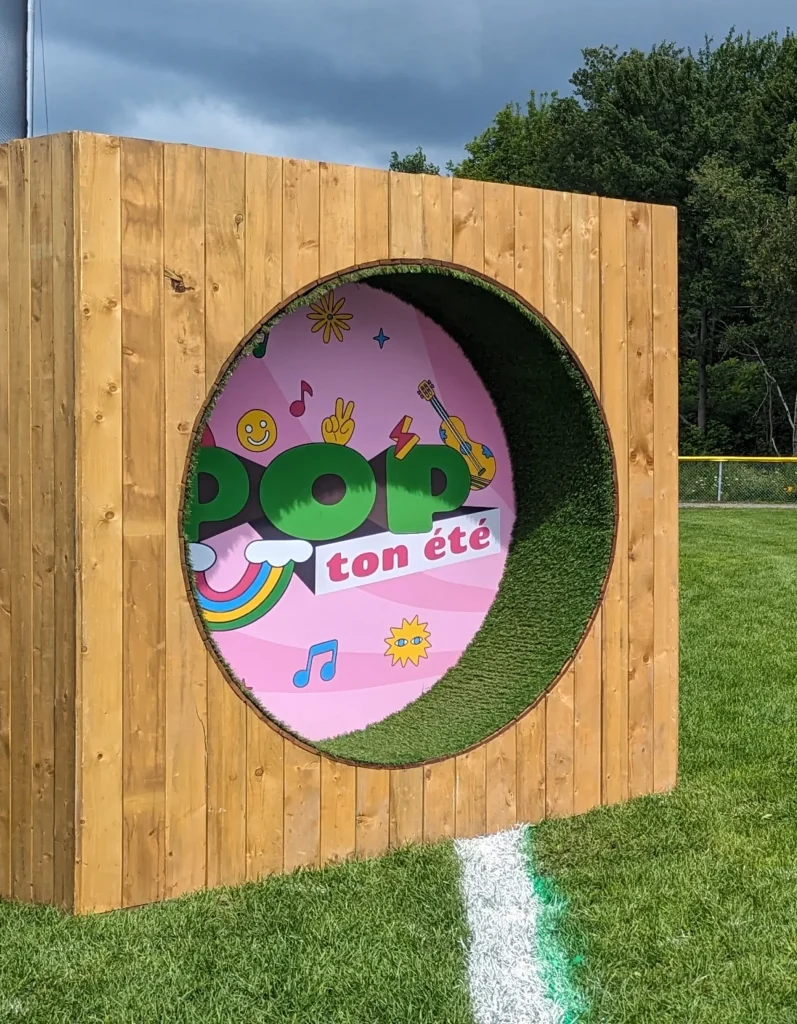 Arche circulaire en bois avec logo POP ton été, entrée du festival à Terrebonne