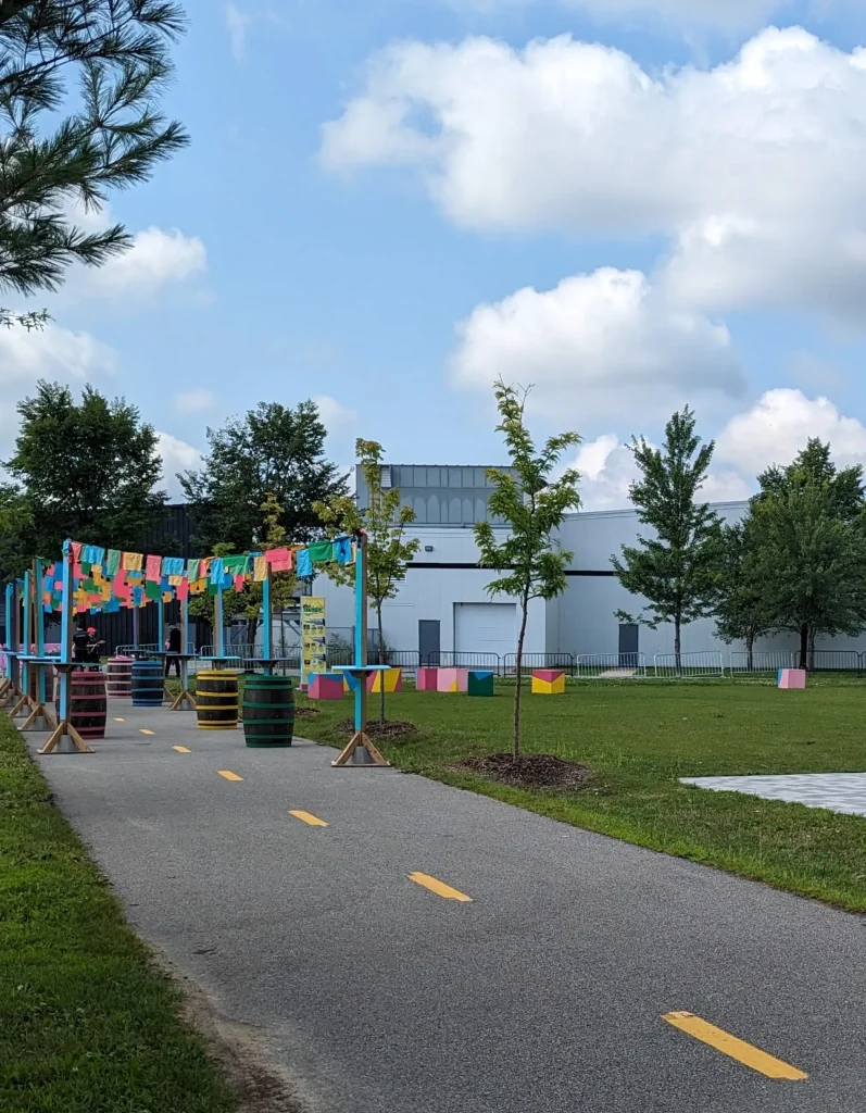 Corridor cyclable décoré de fanions multicolores et tonneaux, festival POP ton été Terrebonne