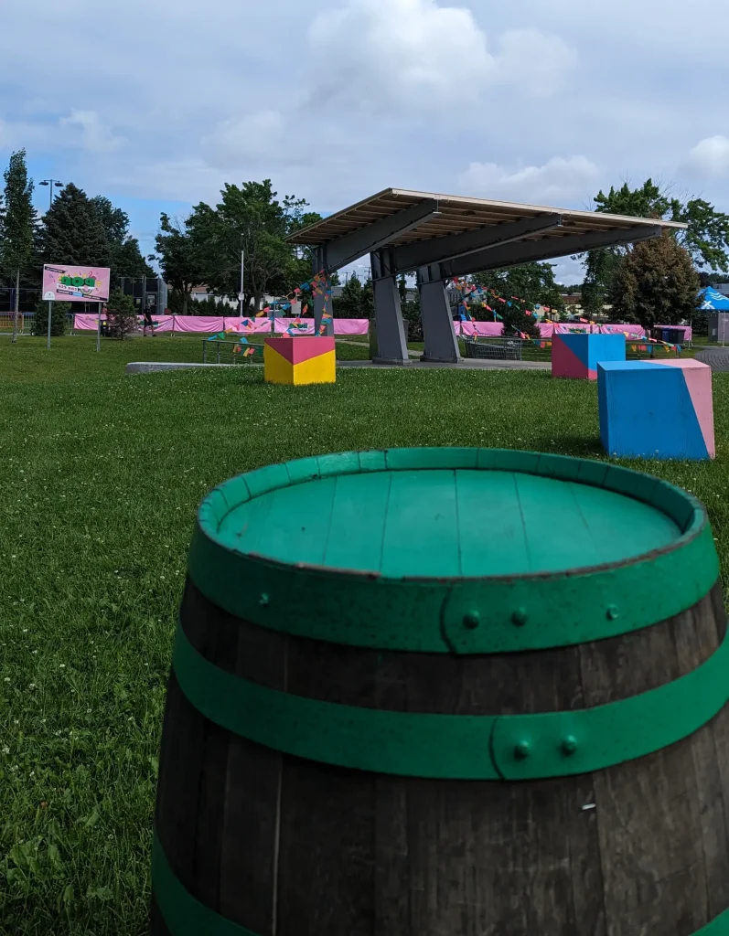 Tonneau-table graphique devant scène couverte et cubes colorés, festival POP ton été Terrebonne