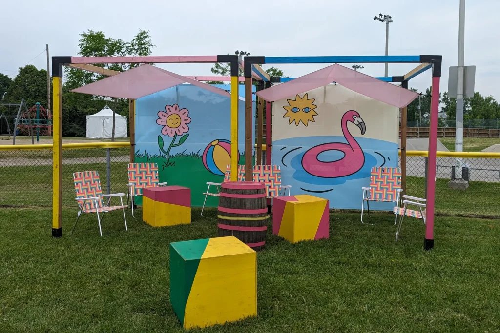 Zone lounge colorée avec pergolas, tonneau-table et chaises, festival POP ton été Terrebonne