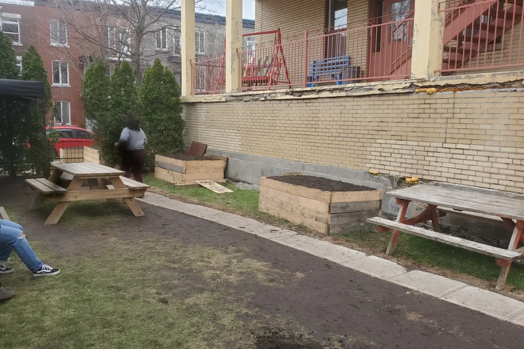 Espace cour avec banc de pique-nique et bacs en bois remplis de terre à Montréal