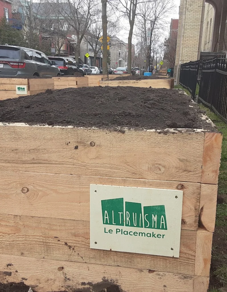 Gros plan d’un bac en bois fraîchement rempli de terre avec plaquette Altruisma à Montréal