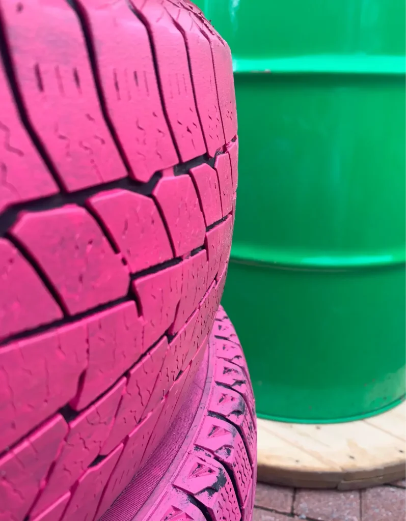 Gros plan de pneu peint rose et baril vert : mobilier recyclé, Laval, Centropolis