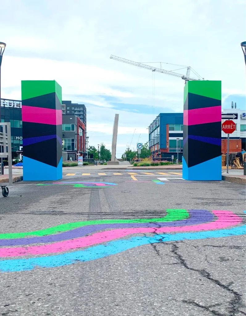 Deux tours graphiques encadrant l’allée, marquage au sol, Centropolis, Laval
