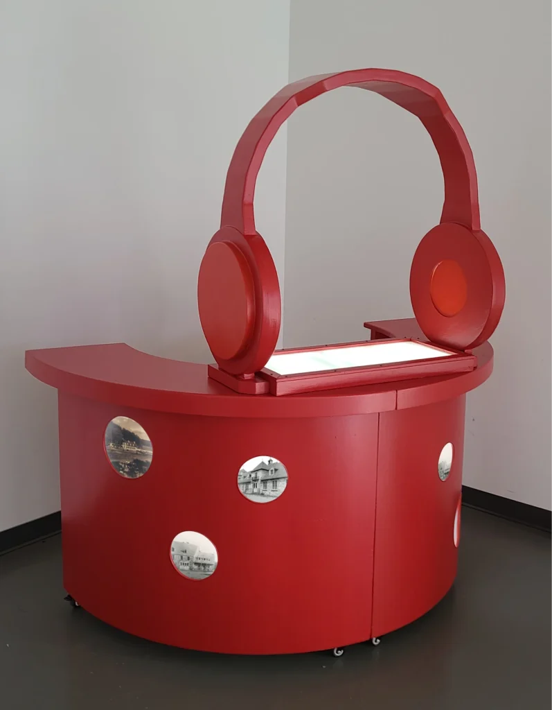 Comptoir de location d’audioguides rouge avec écouteurs géants